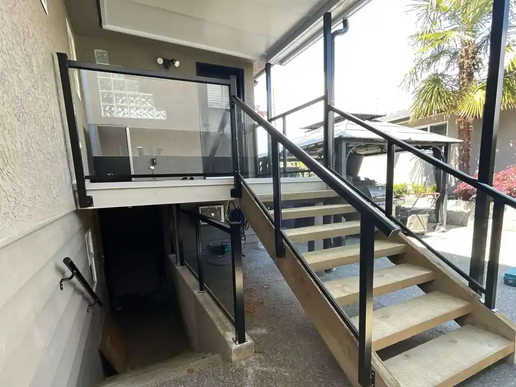 Aluminum-framed glass railing on an exterior stair and landing