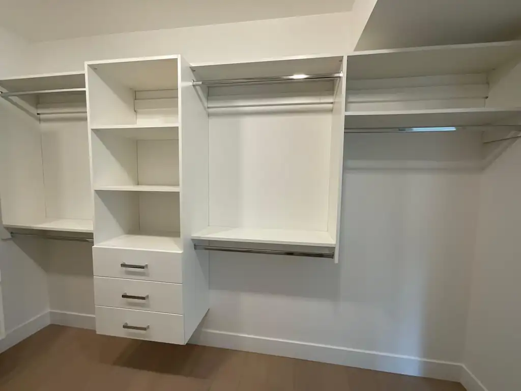 White closet organizer with a central shelf tower and hanging sections