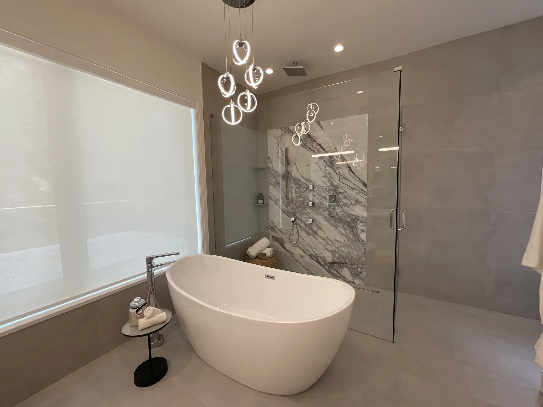 Frameless glass shower beside a freestanding tub, installed by Alpha Glass Ltd