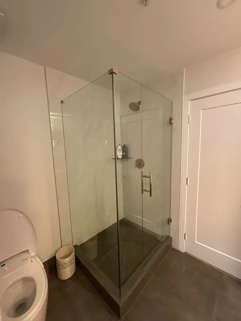Frameless pivot shower door installed by Alpha Glass Ltd in Greater Vancouver