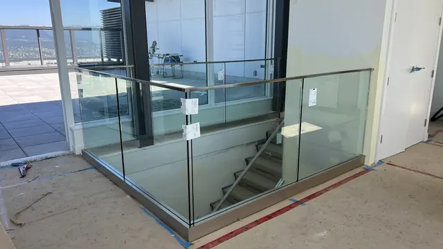 Frameless glass guard around a stair opening at Flamingo Tower, protective film still on