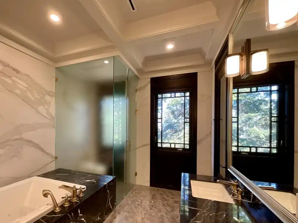 Bathroom glass partition with smart film beside a freestanding tub